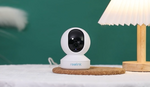 Reolink E1 Pro Just the Right Amount of Everything for Indoor PT Cam, on side table, green wall with lampshade