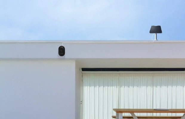 Reolink Argus 3 Ultra 4K Battery/Solar-Powered Standalone WiFi Camera with Color Night Vision on external wall with solar panel mounted to the roof