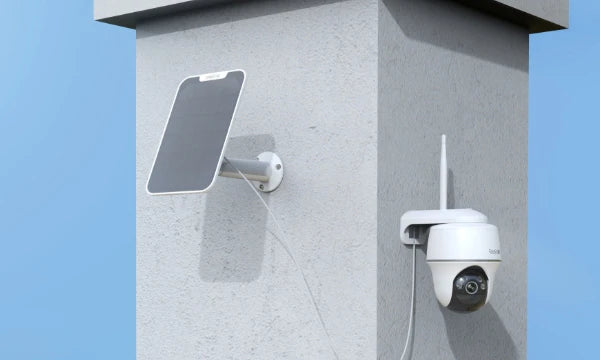 Reolink Argus PT 5MP Wireless Solar Battery Camera with Pan & Tilt mounted on wall plugged into solar panel for constant power