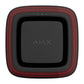 A square black electronic device with rounded corners, featuring a red striped border and the word 'AJAX' printed in gray in the center, shown against a plain white background. there are 3 lights one in red yellow and green, at the top of the face