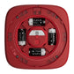 Top-down view of a red square electronic device with four 3V batteries installed in circular slots around the center. The device has a matte red finish with small screw details and printed text, and the batteries & device are labeled AJAX.