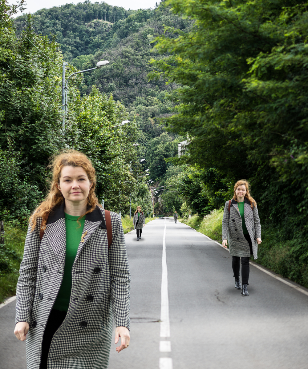 Woman walking on a road appearing at different points at the same time surrounded by greenery
