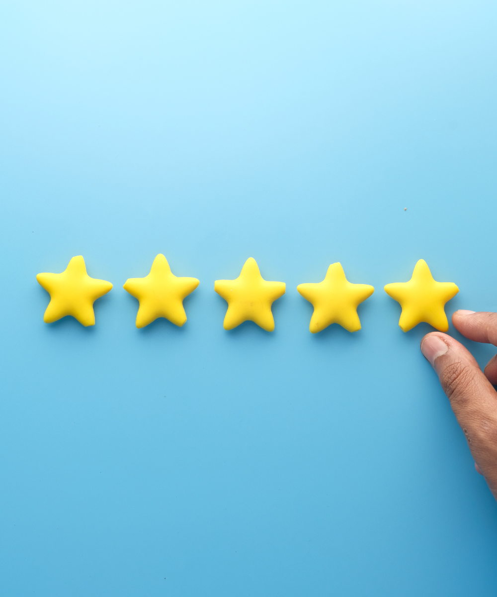 Five yellow stars on a blue background with a hand pointing to the fifth star.