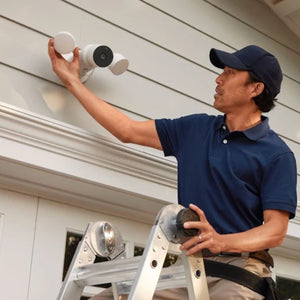 A professional installer helps install a Nest Cam with floodlight on someone's home.