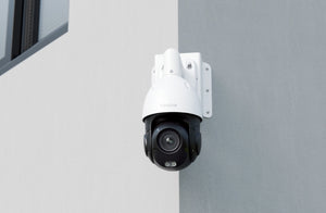 Reolink PTZ camera being held by Reolink RLA-BKC2 corner bracket mount on a white rendered wall