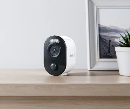 Reolink Argus 3E 3MP Wireless Solar & Battery Powered Security Camera with Smart Detection sitting indoors on table 