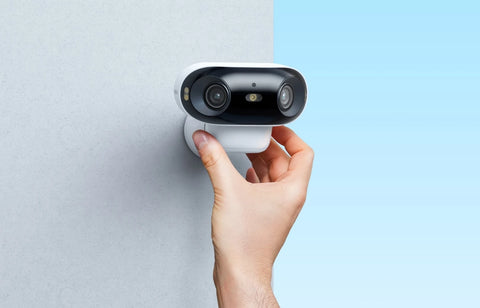 Reolink Argus 4 Pro Smart 4K ColorX Dual-Lens Solar/Battery Camera with 180° Panorama hand placing camera on wall