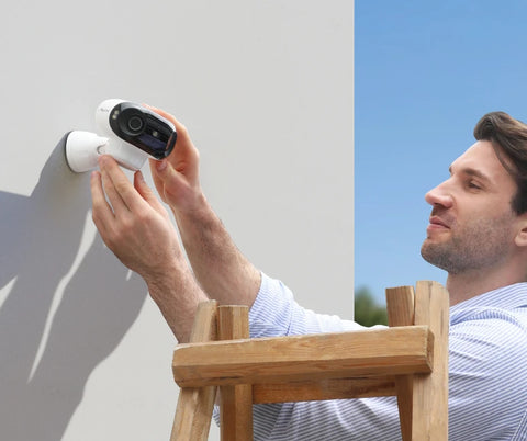 Reolink Argus 4 180° Blindspot-free. 4K Wi-Fi 6 Ready being mounted by a man