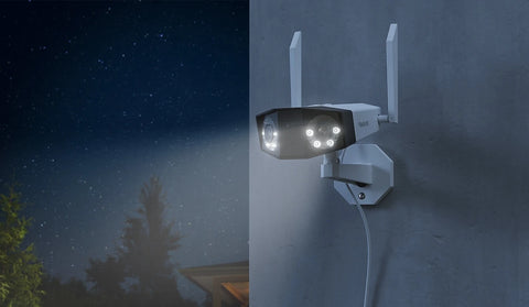 Reolink Duo 2 WiFi 4K 8MP Wi-Fi 6 Plug-in Camera with 180° Panorama mounted on external wall at night emitting white spotlight