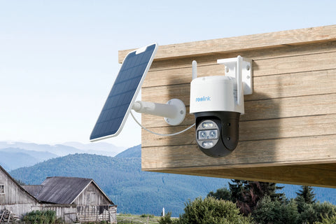 Reolink TrackMix LTE 4G LTE Dual-Lens Battery Security Camera with Auto-Zoom Tracking mounted on wooden porch next to solar panel looking over barns 