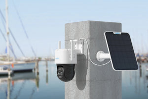Reolink TrackMix LTE 4G LTE Dual-Lens Battery Security Camera with Auto-Zoom Tracking on concrete post with solar panel looking over dockyard
