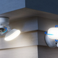 Two reolink elite wifi security cameras with flood lights mounted on a wall corner with adjustable arrow graphics.