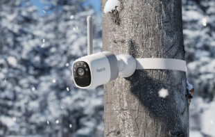 Reolink altas Security camera attached to a tree with a secure strap in a snowy forest