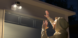 reolink duo floodlight poe above garage door lighting up man in hoodie