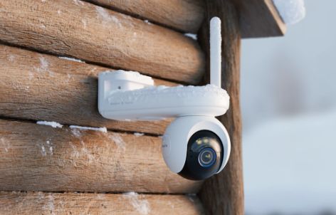 Reolink Altas Go PT White security camera on a wooden surface with a snowy background