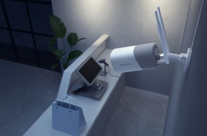 white bullet style security camera on wall looking over a till and shopping bag in a store 