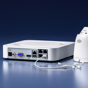 rear of a compact NVR CCTV recorder with for POE ports, vga, hdmi, power, LAN & audio ports plugged into a cctv camera on a blue background
