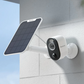 white Reolink Camera mounted on a wall next to a white solar panel