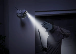 Reolink Lumus Pro Security camera with light shining on a person with a crow bar in the dark