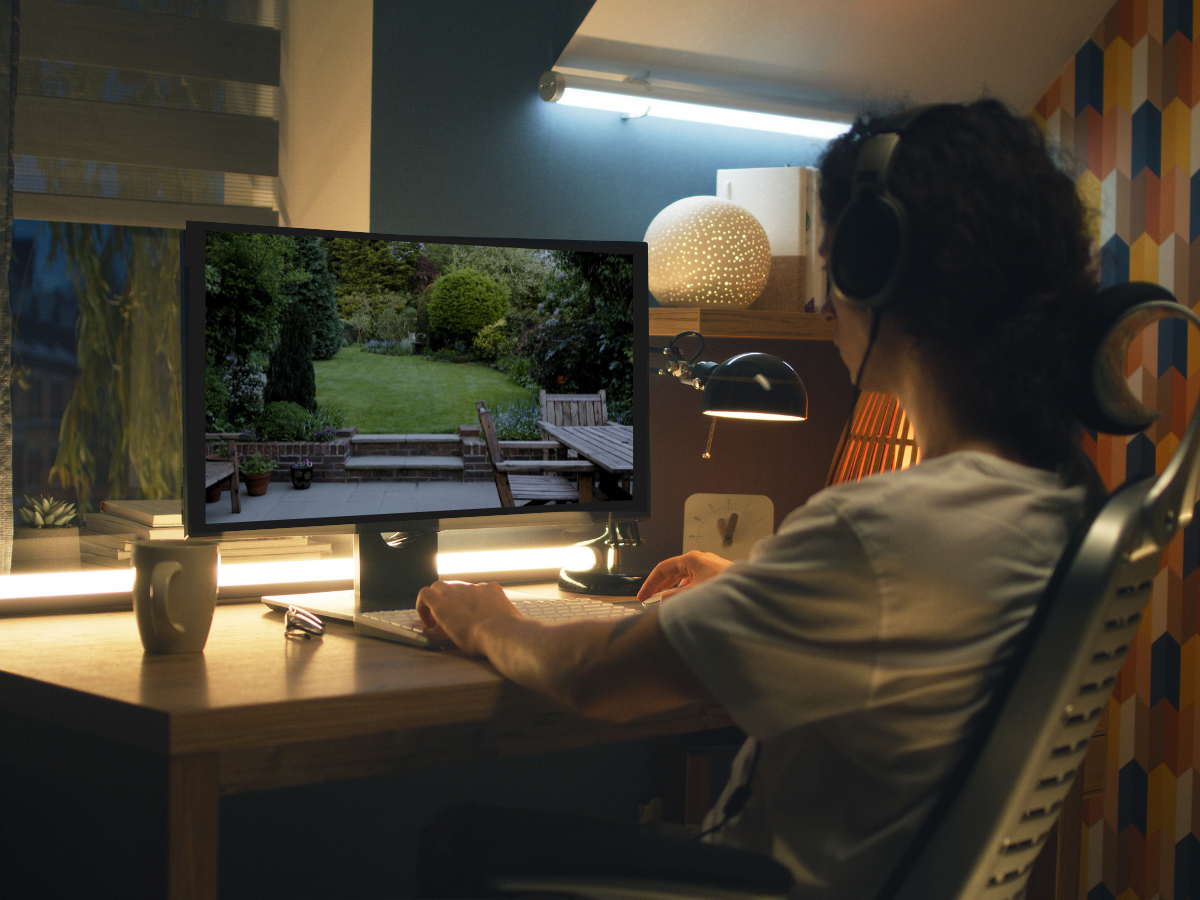 Person sitting at a desk with headphones on, using a computer in a room with colorful walls.